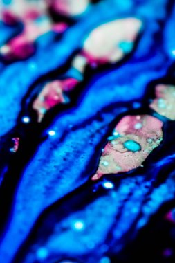 Mavi ve pembe mürekkep beyaz lavaboya dökülmüş ve mürekkep soyut damlalara ve desenlere karışmış..