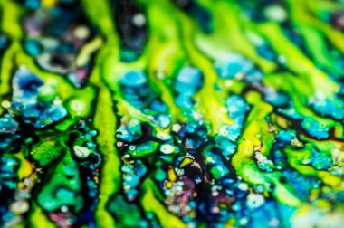 Yazıcı kartuşunu doldurmak için kullanılan mürekkep beyaz lavabonun üzerine dökülmüş ve boyalar soyut damlalar ve desenlerle harmanlanmış..