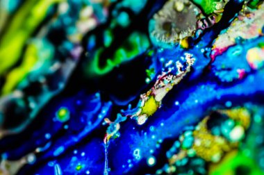 Yazıcı kartuşunu doldurmak için kullanılan mürekkep beyaz lavabonun üzerine dökülmüş ve boyalar soyut damlalar ve desenlerle harmanlanmış..