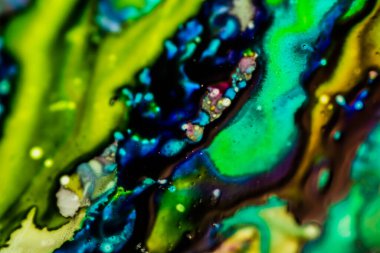 Yazıcı kartuşunu doldurmak için kullanılan mürekkep beyaz lavabonun üzerine dökülmüş ve boyalar soyut damlalar ve desenlerle harmanlanmış..