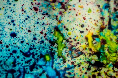 Yazıcı kartuşunu doldurmak için kullanılan mürekkep beyaz lavabonun üzerine dökülmüş ve boyalar soyut damlalar ve desenlerle harmanlanmış..