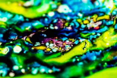 Yazıcı kartuşunu doldurmak için kullanılan mürekkep beyaz lavabonun üzerine dökülmüş ve boyalar soyut damlalar ve desenlerle harmanlanmış..