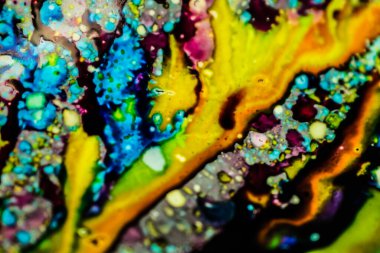 Yazıcı kartuşunu doldurmak için kullanılan mürekkep beyaz lavabonun üzerine dökülmüş ve boyalar soyut damlalar ve desenlerle harmanlanmış..