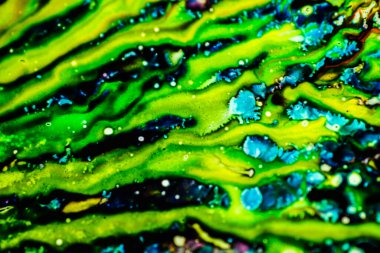 Yazıcı kartuşunu doldurmak için kullanılan mürekkep beyaz lavabonun üzerine dökülmüş ve boyalar soyut damlalar ve desenlerle harmanlanmış..