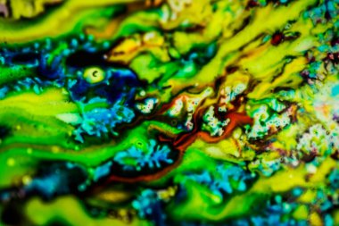 Yazıcı kartuşunu doldurmak için kullanılan mürekkep beyaz lavabonun üzerine dökülmüş ve boyalar soyut damlalar ve desenlerle harmanlanmış..