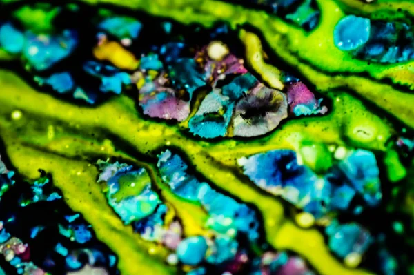 Yazıcı kartuşunu doldurmak için kullanılan mürekkep beyaz lavabonun üzerine dökülmüş ve boyalar soyut damlalar ve desenlerle harmanlanmış..