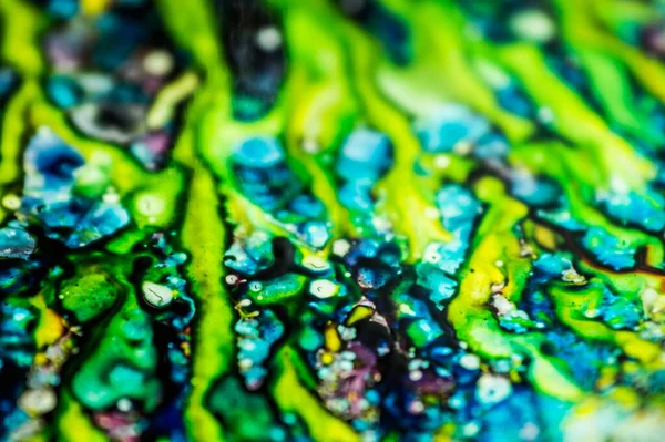 Yazıcı kartuşunu doldurmak için kullanılan mürekkep beyaz lavabonun üzerine dökülmüş ve boyalar soyut damlalar ve desenlerle harmanlanmış..