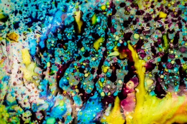 Yazıcı kartuşunu doldurmak için kullanılan mürekkep beyaz lavabonun üzerine dökülmüş ve boyalar soyut damlalar ve desenlerle harmanlanmış..