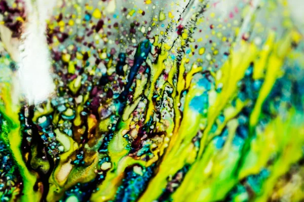 The ink to refill the printer cartridge was spilled onto the white washbasin and the paints blended into abstract drips and patterns.