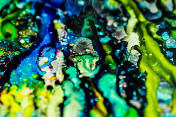 The ink to refill the printer cartridge was spilled onto the white washbasin and the paints blended into abstract drips and patterns.