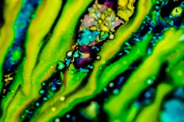 Yazıcı kartuşunu doldurmak için kullanılan mürekkep beyaz lavabonun üzerine dökülmüş ve boyalar soyut damlalar ve desenlerle harmanlanmış..