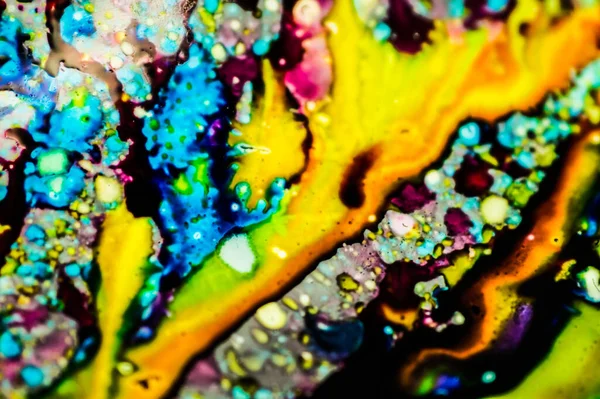 Yazıcı kartuşunu doldurmak için kullanılan mürekkep beyaz lavabonun üzerine dökülmüş ve boyalar soyut damlalar ve desenlerle harmanlanmış..