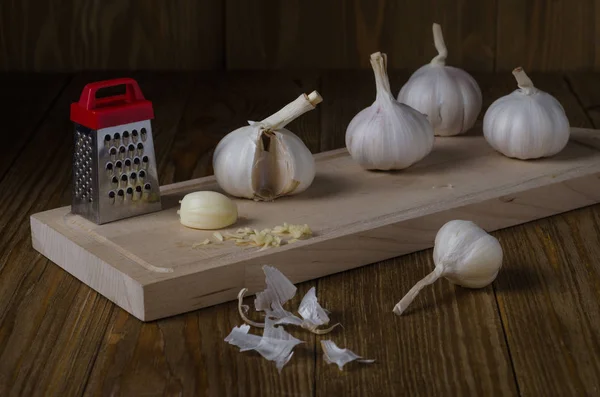 Stilleven Van Knoflook Hoofden Een Cutting Board Een Houten Tafel — Stockfoto