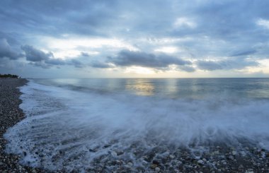 Deniz şafak. Hareket, yükselen güneşin arka planda dalgalar dondu. Soğuk mavi renk tonu.