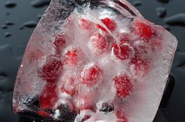 Buz siyah zemin üzerine kırmızı meyveler