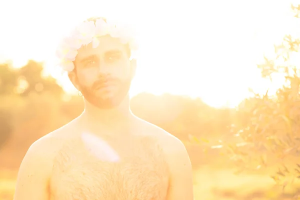 日落时有花冠和裸胸的男子 — 图库照片