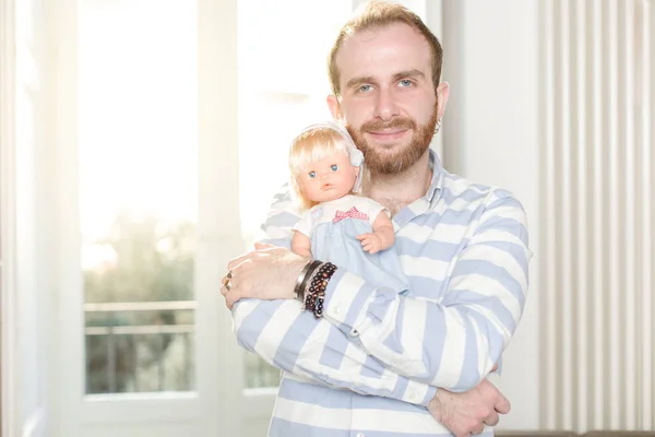 Glimlachende Redhead Man Met Baard Knuffelen Een Pop Stockfoto