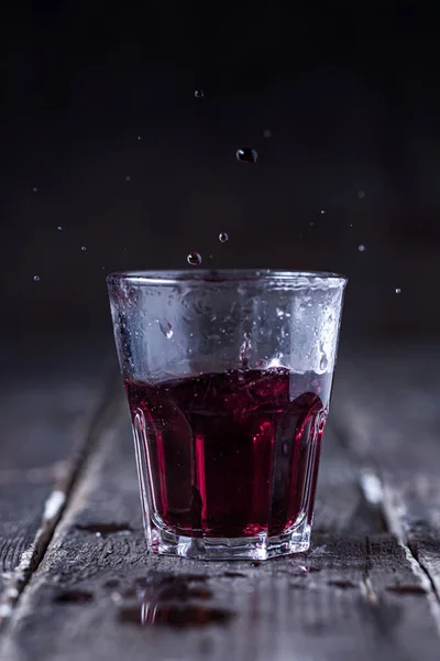Shot Red Bitter Liquor Drops Splashing Wood — Stock Photo, Image