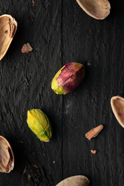黑木表面上有散落的胡桃壳碎片的梨子 — 图库照片