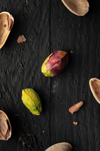 Pistache Sur Une Surface Bois Noir Avec Morceaux Coquille Éparpillés — Photo