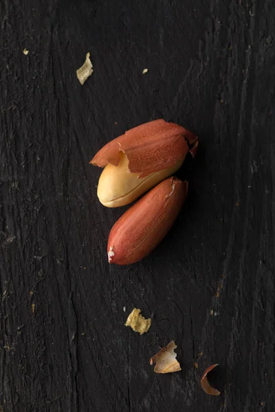 Dois Amendoins Superfície Madeira Preta — Fotografia de Stock