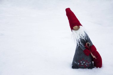 Yeni yıl cücesi hafif bir arka planda hediye çantasıyla.