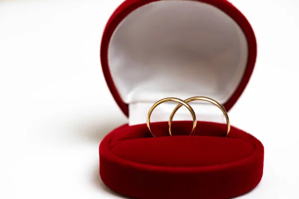 Anneaux de mariage dorés dans une boîte cadeau rouge isolé sur un fond blanc . — Photo