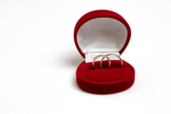 Golden wedding rings in a red gift box isolated on a white background.