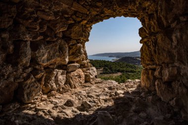 Körfez manzarası ve tepedeki Kritinia Kalesi 'nden ağaçlar.