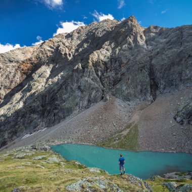 Gradental Milli Parkı 'ndaki Vordersee turkuaz gölünde duran adam arkasında dağ olan Hohe Tauern, Avusturya