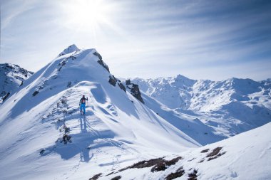 Zillertal Hochfuegen dağlarında kayak yapan bir adam, Kraxentrager 'ın zirvesine tırmanmak için dağ manzarasının önünde,