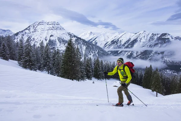 Karwendelの山の中で男のスキーツアーは 山の景色の前で スキーで山のピークSchediatorを登る — ストック写真