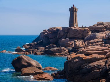 Büyük pembe granit kayalar ve P yakınlarındaki bir deniz feneri ile Seascape