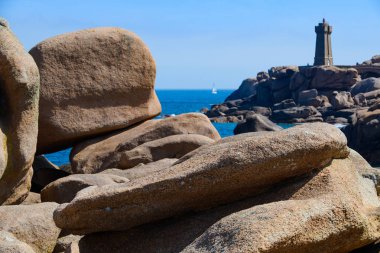 Büyük pembe granit kayalar ve P yakınlarındaki bir deniz feneri ile Seascape