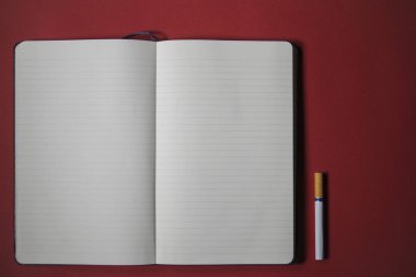 kırmızı bir arka plan üzerinde sigara ve dizüstü yazma