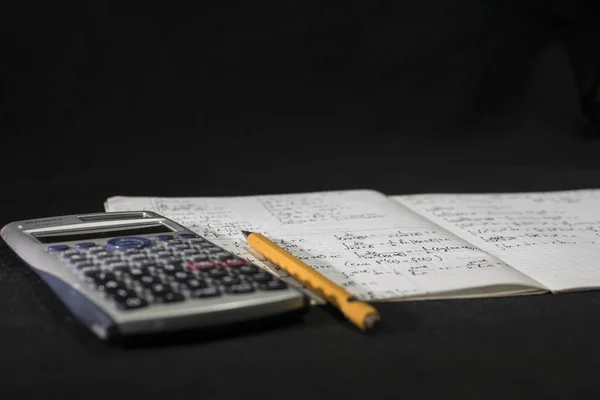 matematik ders kitabı, defter, kalem ve hesap makinesi