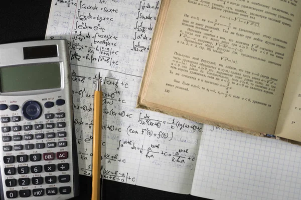 matematik ders kitabı, defter, kalem ve hesap makinesi