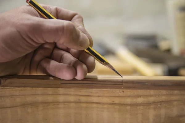 Carpintero con un lápiz marca la pieza de trabajo —  Fotos de Stock