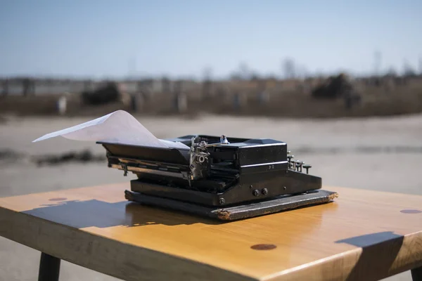 Пишущая машинка на столе на открытом воздухе, эстуарий на заднем плане Лицензионные Стоковые Изображения