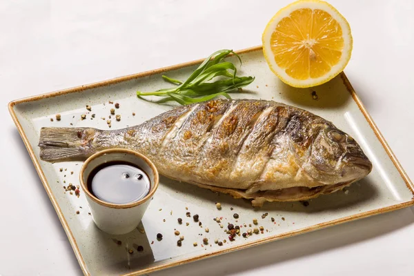 Смажена риба Дорада, лимон, гранатовий соус — стокове фото