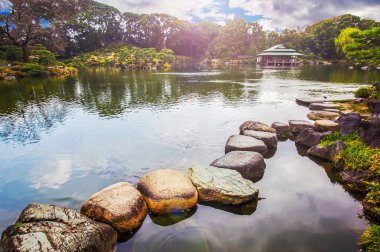 Kiyosumi bahçesinin güzel manzarası Wateau 'da taş patikası ve uzak mesafedeki çay evi. r. Tokyo, Japonya