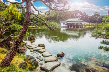 Kiyosumi bahçesinin güzel bir manzarası var. Su yolu taştan, çay evi uzaktan. r. Tokyo, Japonya