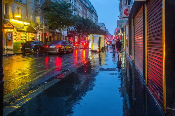 Amazing Paris  in rain! Red lights of cars and cafe  and blue sky - in blue hour (twilights) . Reflection of wet asphalt .- photography look like painting of impressionist painter Pissarro !