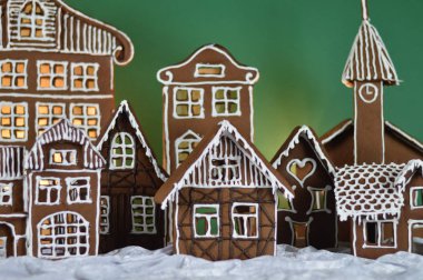 ev dekorasyon varış zamanında olarak, beyaz snowlike kadifeyi geleneksel tatlı gingerbread köyü yeşil arka plan önünde made
