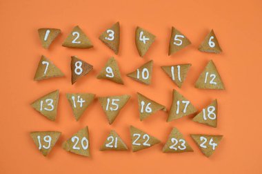 24 numaralı ve advent çerezleri turuncu zemin üzerine sıralanmış