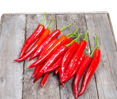 Ahşap zeminde taze biberler, beyaz arka planda izole edilmiş.