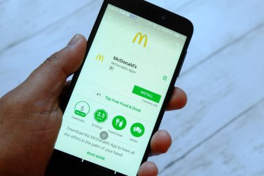 Bandar Seri Begawan, Brunei - 25 Temmuz 2018: Mcdonald's app ile akıllı telefon android Google oyun satan bir yerde tutan bir erkek el.