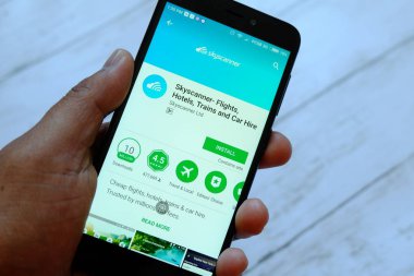 Bandar Seri Begawan, Brunei - 25 Temmuz 2018: Skyscanner app ile akıllı telefon android Google oyun satan bir yerde tutan bir erkek el