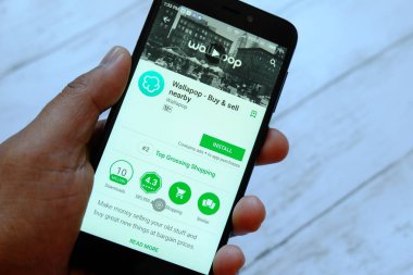 Bandar Seri Begawan, Brunei - 25 Temmuz 2018: Wallapop uygulaması ile smartphone android Google oyun satan bir yerde tutan bir erkek el