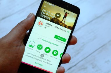 Bandar Seri Begawan, Brunei - 25 Temmuz 2018: Udemy apps ile akıllı telefon android Google oyun satan bir yerde tutan bir erkek el